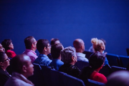 People meeting in an auditorium sitting